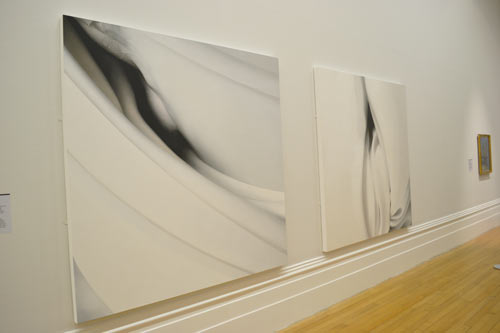 Black and white paintings hanging in a gallery