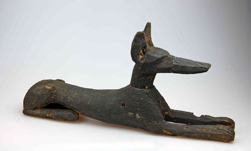 wooden sculpture of a recumbent jackal