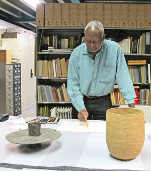 Atta Kwami sketching African artefacts in the museum store