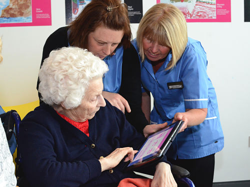 Health care professionals and person living with dementia using My House of Memories app