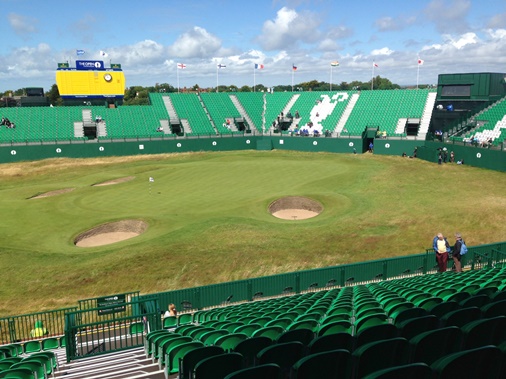Image of fairway and golf green with stands in background
