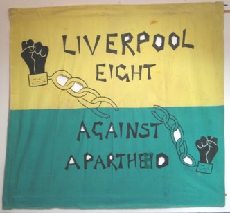 green and yellow banner with the words Liverpool 8 against apartheid