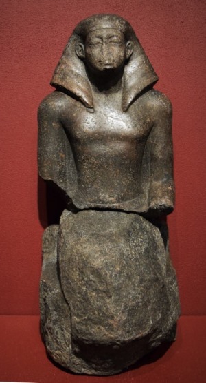 Frontal image of a statue showing a seated man