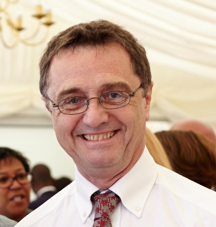 man in glasses tie and white shirt smilng 