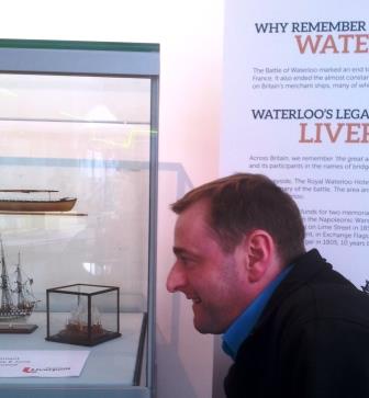 Mike Butchard, Visitor Assistant, inspects one of the miniature ship models.