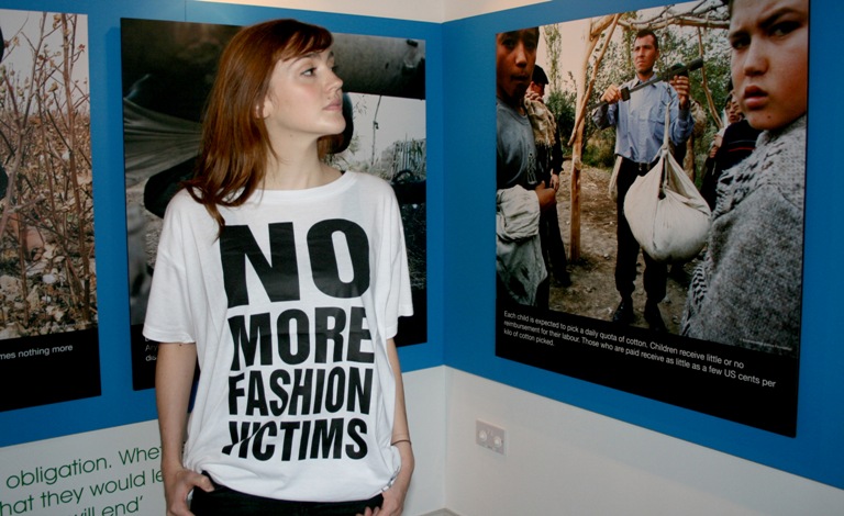 Staff in anti slavery t shirt looking at text panel on wall