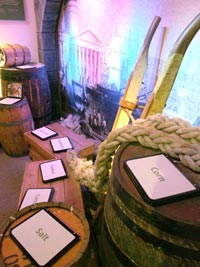 Gallery shot showing barrels with signs reading corn, salt and sugar.
