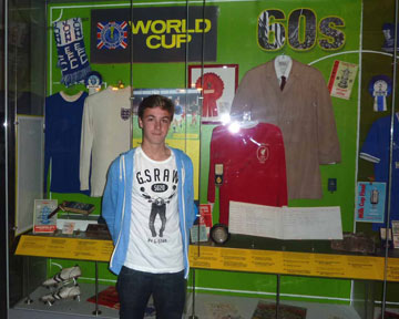 Ben Forshaw stood next to a display cas with football objects at the Museum of Liverpool
