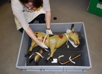 woman getting a large model horse out of a box