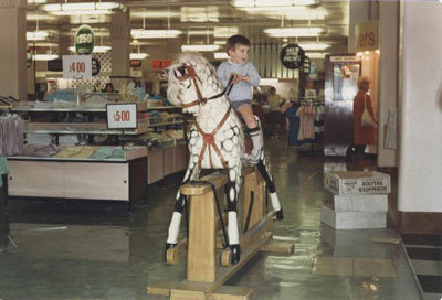 young boy riding rocking horse in Blacklers department store