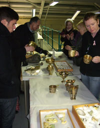 people studying artefacts on a table 