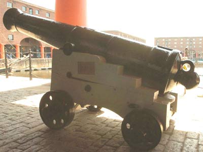 colour photo of a large cannon on a dockside