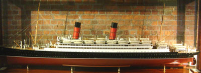 large ship model of a liner with two red funnels, lots of life boats and masts