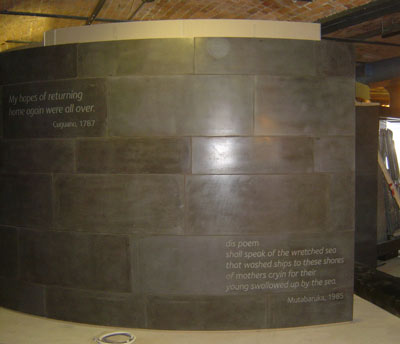 a shiny curved grey wall with writing on it