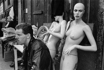 photo of a man sitting in front of mannequins
