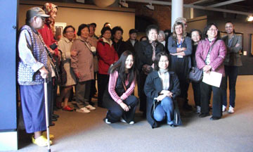 group photo of museum staff and visiting Chinese elders in the museum