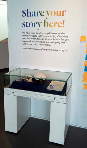 display case with text 'Share your story here!' on the wall above it