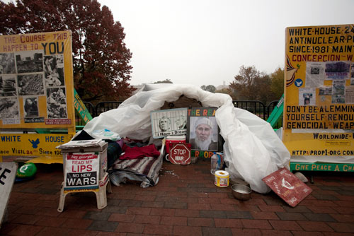 tent surrounded by protest signs and banners
