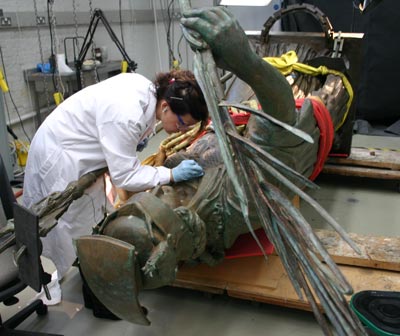 Conservator working on a sculpture