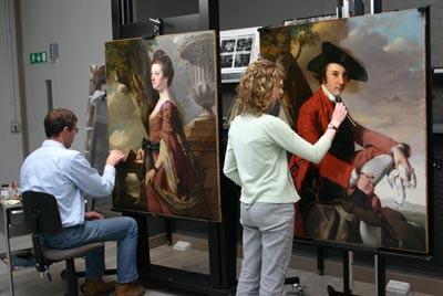 conservators working on 2 paintings