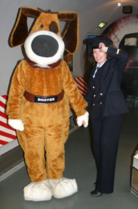 Roleplayers dressed as a customs officer and sniffer dog