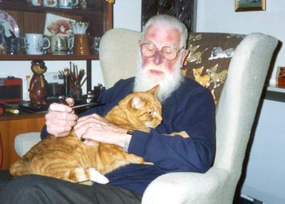 An old man with a cat on his knee