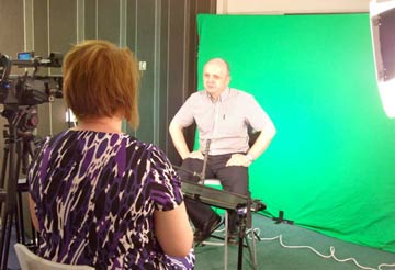 man being interviewed in front of a green screen