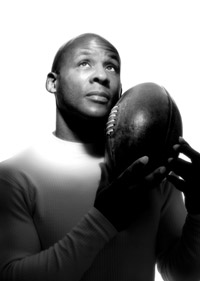A portrait shot of man looking upwards and holding a rugby ball
