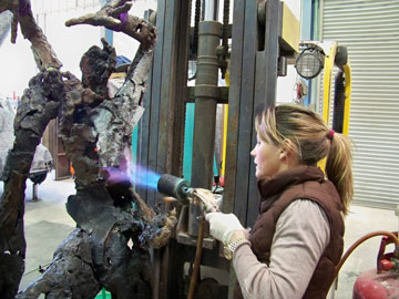 Artist working on a sculpture with a blow torch