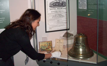 Photo of curator installing bell in case
