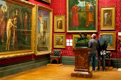 visitors looking at paintings in a gallery