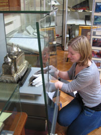 curator putting objects in a display case