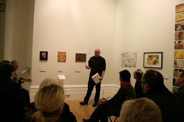 Artist talks to audience in gallery