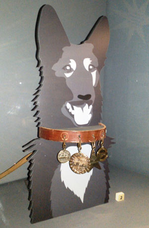 collar, lead and medals displayed on a figure of a dog