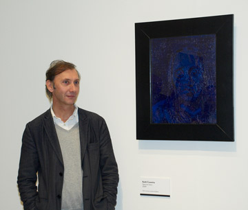Man standing next to a blue portrait painting