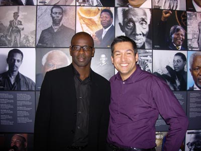two men posing for a photo in front of a museum display