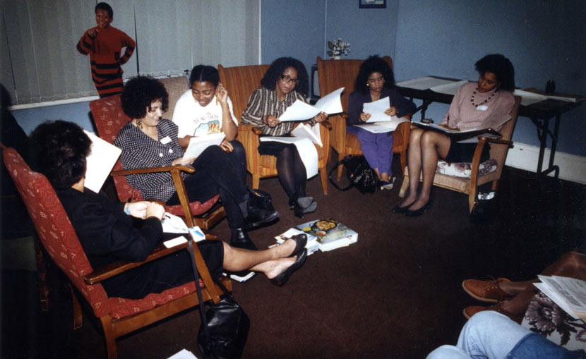 Women sat in a circle, looking at documents