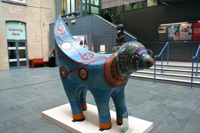 A brightly coloured sculpture with the head of a lamb and a tail shaped like a banana