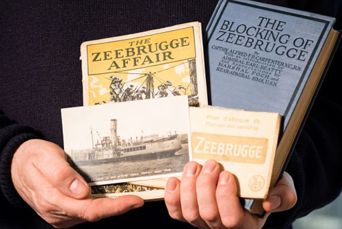 man holding old books about the First World War