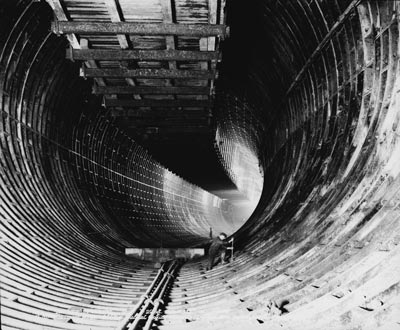 photograph of solitary construction worker in an enormous tunnel