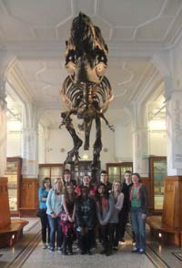 group of volunteers standing in front of a Tyrannosaurus Rex in Manchester Museum
