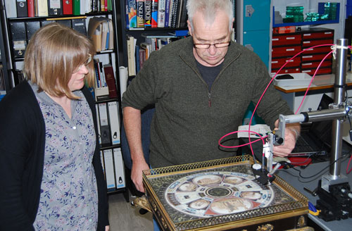 conservators using technical equipment to examine a decorative table
