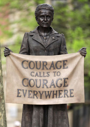 statue of woman holding a banner saying: Courage calls to courage everywhere