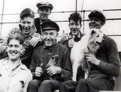 Sailors, a dog and a monkey pose for a photo