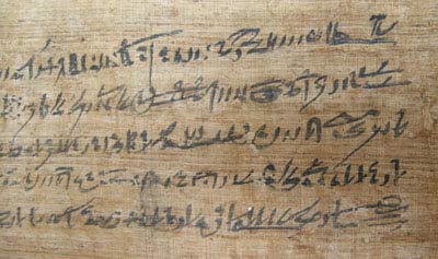 a piece of brown paper with black Egyptian text on it