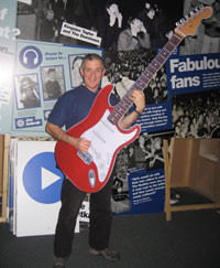 man holding a giant cut-out guitar