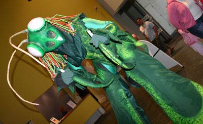 a stiltwalker in a green preying mantis outfit