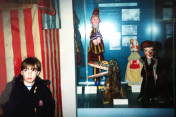 Laura stands next to the Punch and Judy show