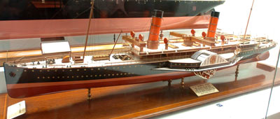 model of a long thin ship with a paddle on the side, two red funnels and a couple of masts fore and aft