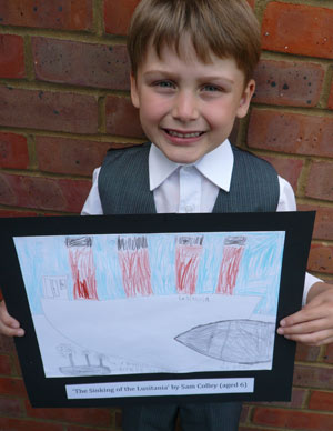 young boy holding up a drawing